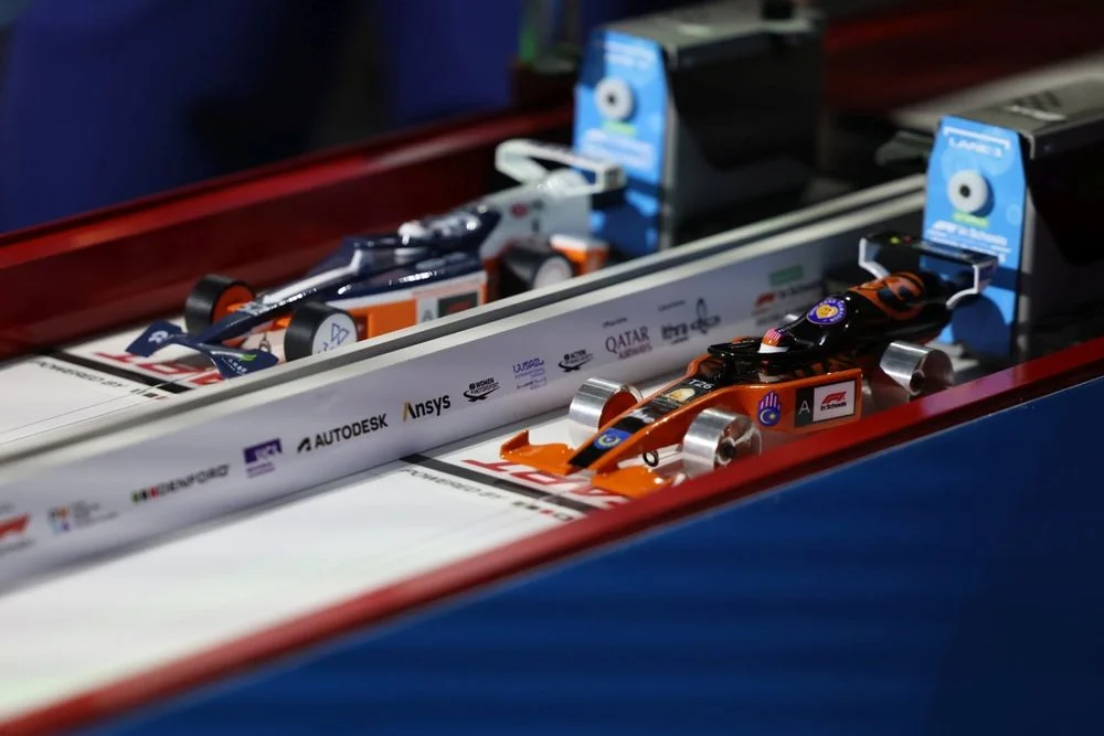 Miniature F1-style cars on the STEM Racing track